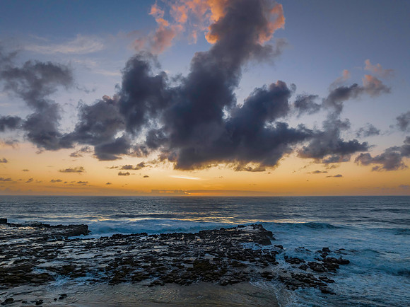 Surfs up sunrise at the seaside with scattered clouds