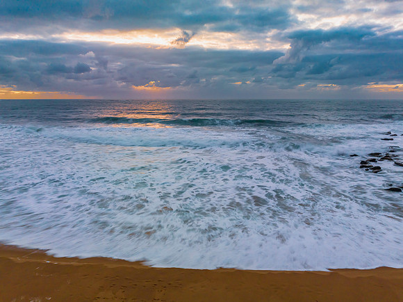 Sunrise and a cloud covered sky at the beach