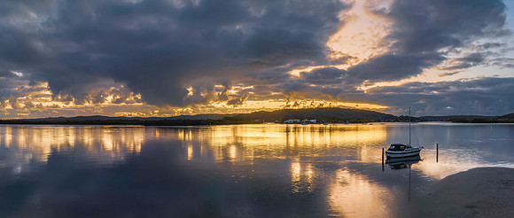 Sunrise over the bay with clouds and reflections