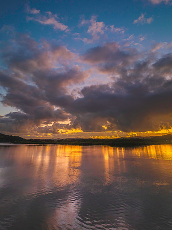 Sunrise over the bay with clouds and reflections