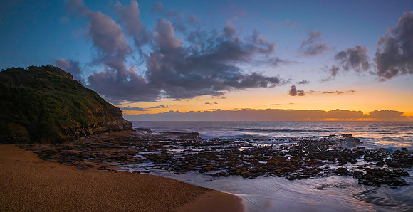 Dawn panorama with headland, beach and rock platform
