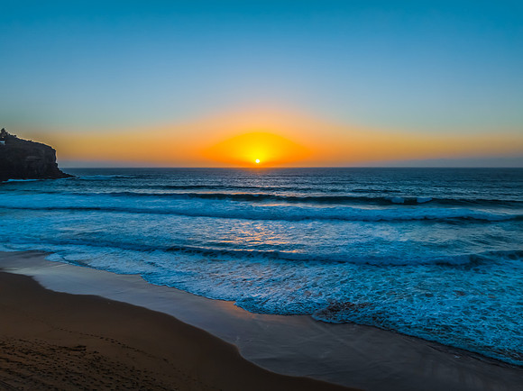 Sunrise at the Seaside with a hazy cloudless sky