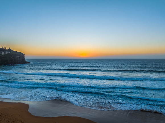 Sunrise at the Seaside with a hazy cloudless sky