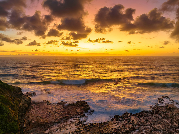 Surfs up sunrise at the seaside with scattered clouds