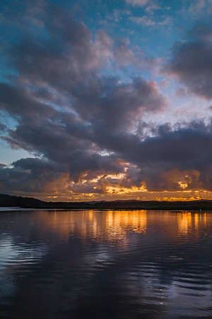 Sunrise over the bay with clouds and reflections