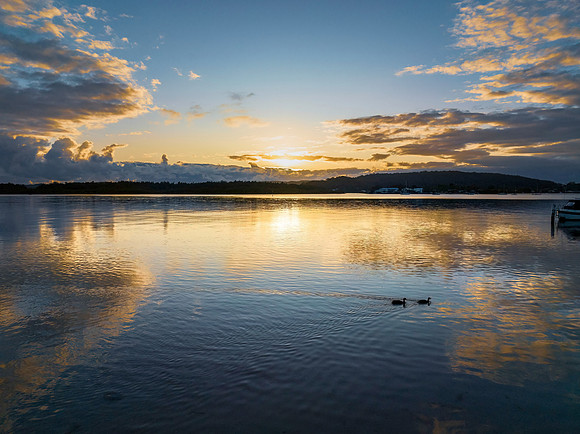 Sunrise over the bay with clouds and reflections