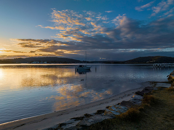Sunrise over the bay with clouds and reflections