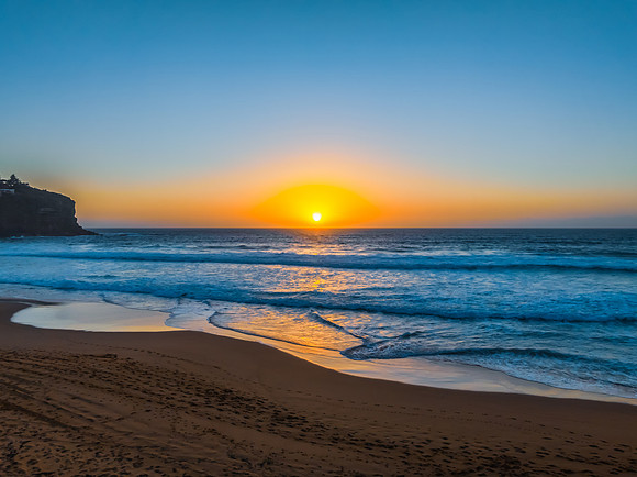 Sunrise at the Seaside with a hazy cloudless sky