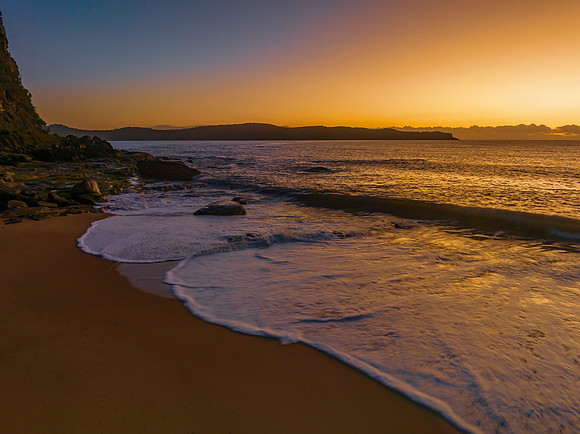 Aerial sunrise seascape with clear skies and low cloud bank