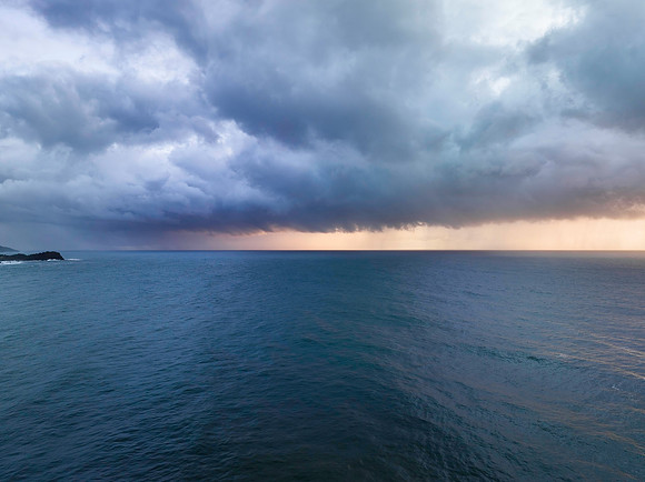 Rain clouds and storm light sunrise seascape