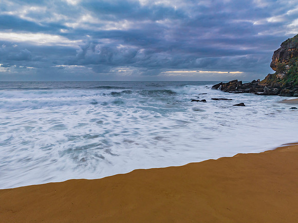 Sunrise and a cloud covered sky at the beach