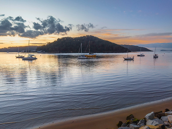 Aerial sunrise waterscape with boats and scattered clouds