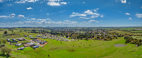 Aerial views over the quiet countryside with white puffy clouds
