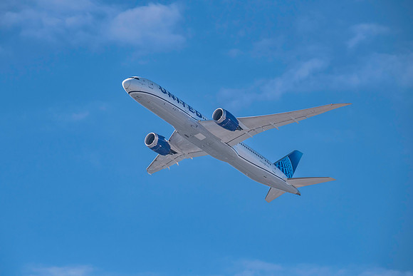United Dreamliner aircraft flying in the beautiful blue morning