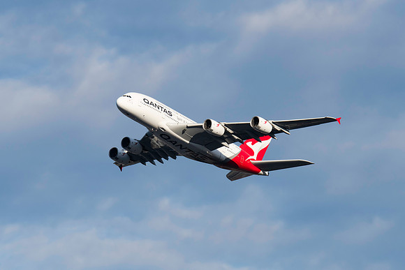 Qantas aircraft flying in the afternoon blue sky