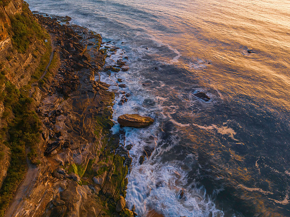 Aerial sunrise seascape with clear skies and low cloud bank