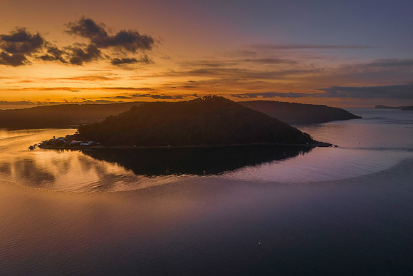 Aerial sunrise waterscape with boats and scattered clouds