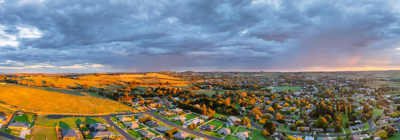 Sunrise and rain clouds over the countryside and town