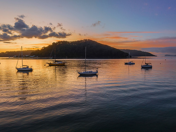 Aerial sunrise waterscape with boats and scattered clouds