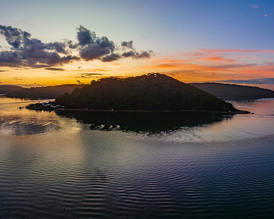 Aerial sunrise waterscape with boats and scattered clouds