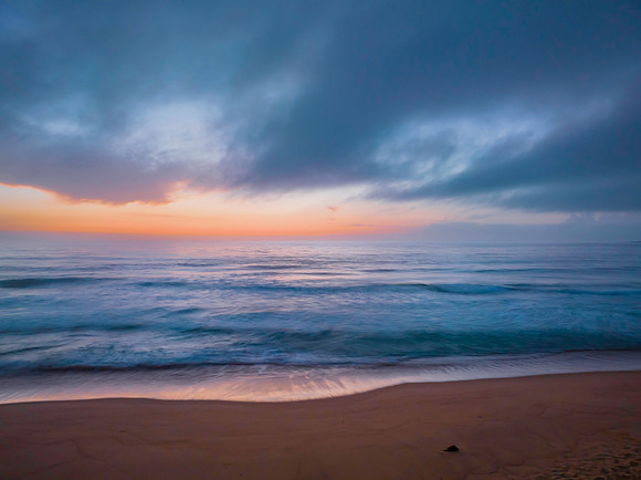 Summer sunrise at the seaside with clouds and haze