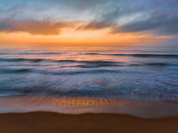 Summer sunrise at the seaside with clouds and haze