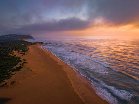 Summer sunrise at the seaside with clouds and haze