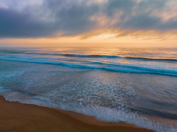 Summer sunrise at the seaside with clouds and haze