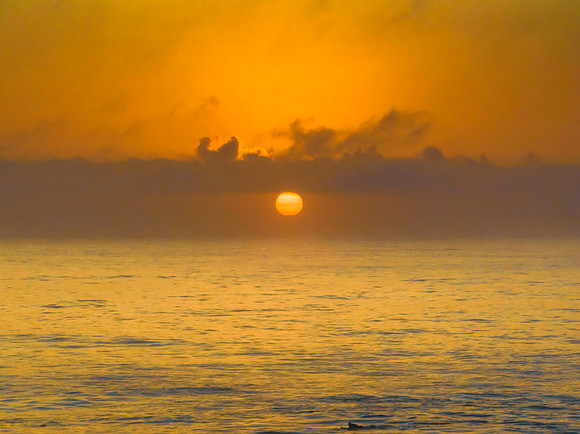 Summer sunrise at the seaside with clouds and haze