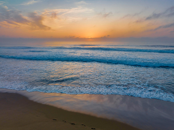 Summer sunrise at the seaside with clouds and haze