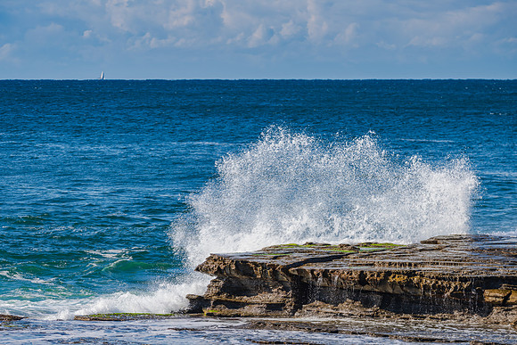 Splashes and morning seascape at rocky inlet