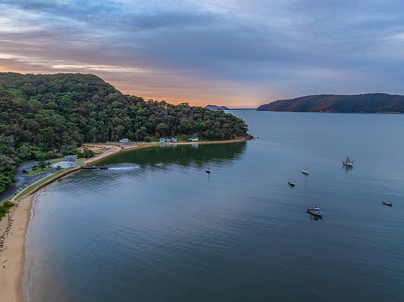 Sunrise over the bay with boats and cloud covered sky