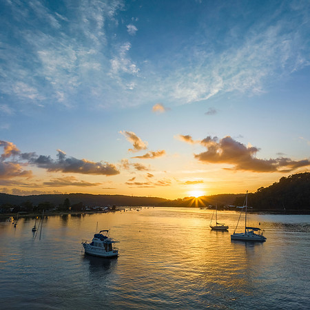 Aerial sunrise waterscape with boats and scattered clouds