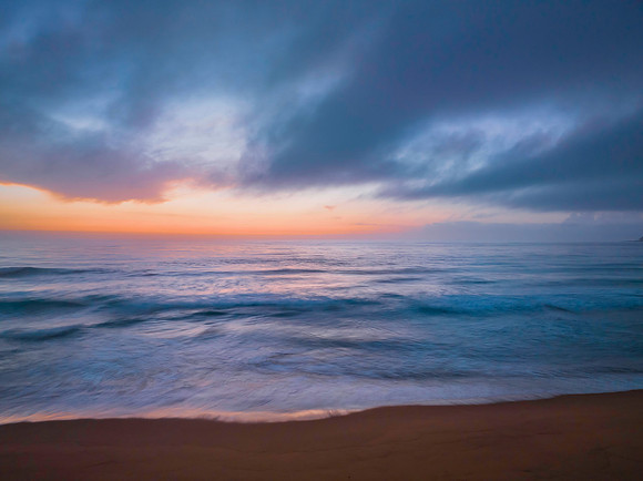 Summer sunrise at the seaside with clouds and haze