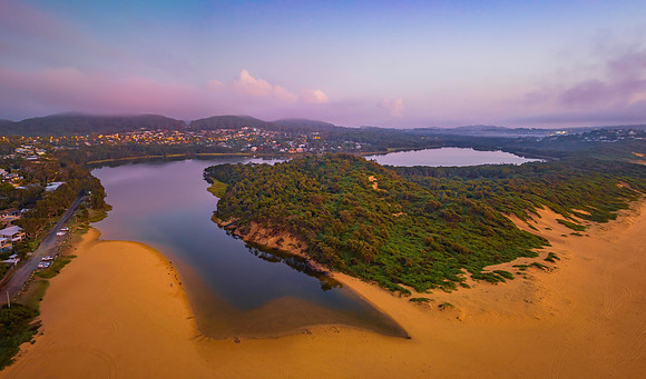 Summer sunrise panorama at the beach and lagoon with clouds and