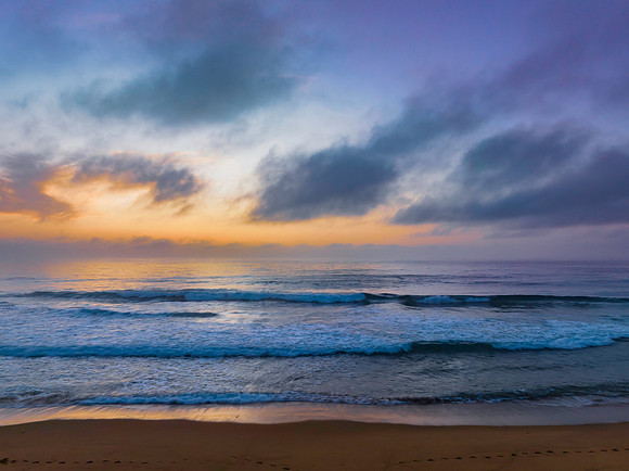 Summer sunrise at the seaside with clouds and haze