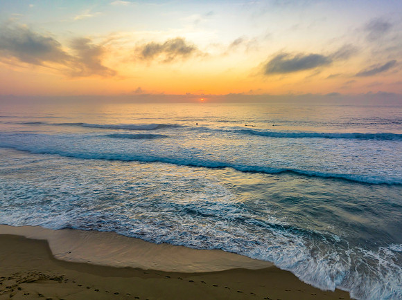 Summer sunrise at the seaside with clouds and haze