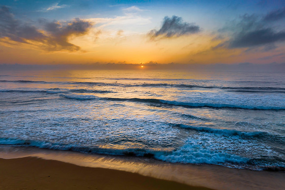 Summer sunrise at the seaside with clouds and haze
