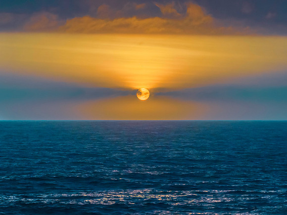 Early morning sun rising in the haze over the ocean