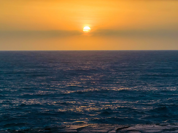 Early morning sun rising in the haze over the ocean