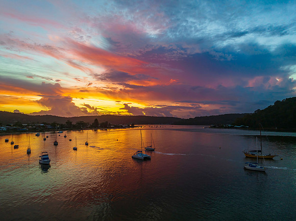 Aerial sunrise waterscape with boats, colour and clouds
