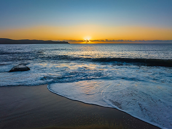 Aerial sunrise seascape with clear skies and sunrays