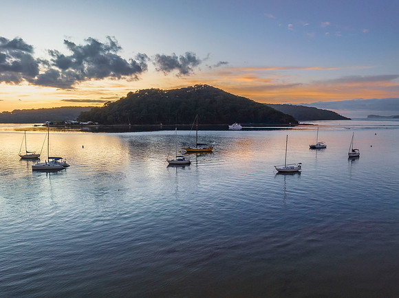 Aerial sunrise waterscape with boats and scattered clouds