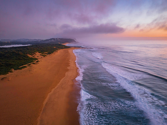Summer sunrise at the seaside with clouds and haze