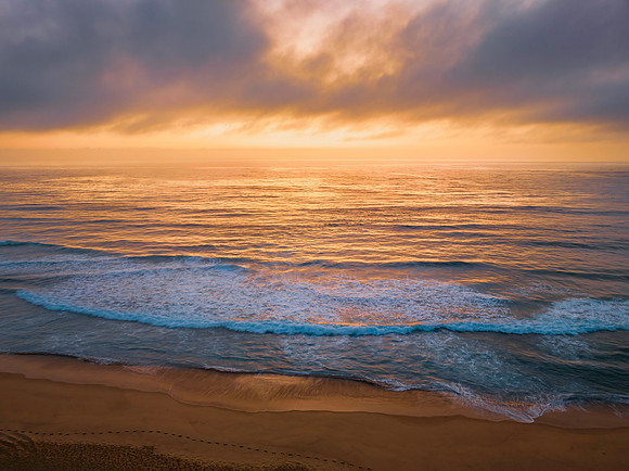 Summer sunrise at the seaside with clouds and haze