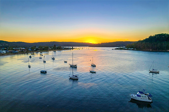 Aerial sunrise waterscape with boats and clear skies