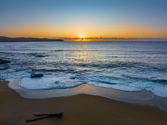 Aerial sunrise seascape with clear skies and sunrays