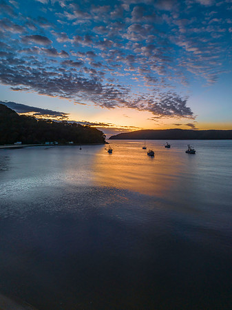 Sunrise views over Brisk Bay with boats, clouds and mountain ran