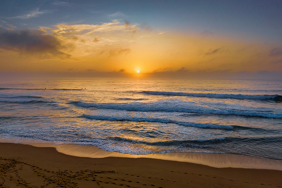 Summer sunrise at the seaside with clouds and haze