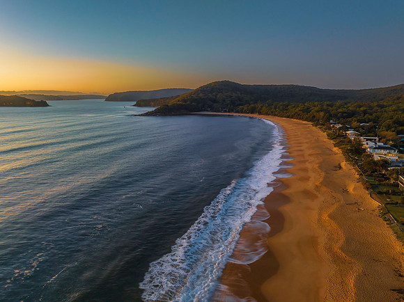 Aerial sunrise seascape with clear skies and low cloud bank